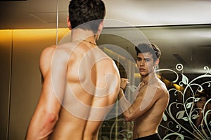 Young Man Admiring Bicep Muscles in Mirror