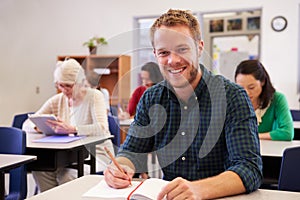 Young man at an adult education class looking to camera