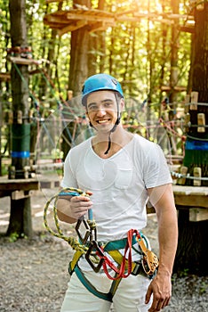 Young man in adventure rope park. Climbing Equipment.