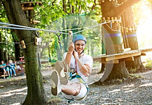 Young man in adventure rope park. Climbing Equipment.