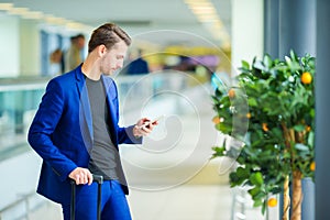 Young man in airport with baggage waiting boarding