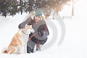Young man with akita dog pet in park on snowy day.