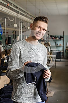 a young man analysing the work at the linking machine for knitting in textile industry