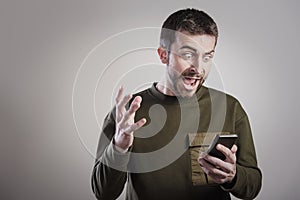 Man angry at his phone, outraged and enraged