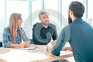 young man answering questions from managers during an interview.