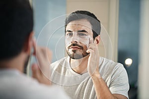 Young Man Applying Anti-aging Lotion fot Skin Care