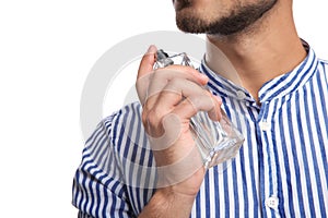 Young man applying perfume on white background