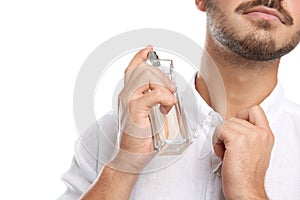 Young man applying perfume on white background