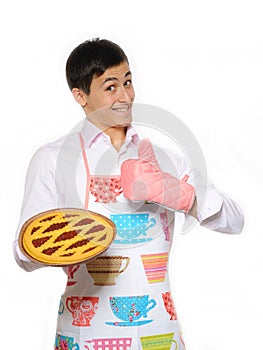 Young man in apron baked tasty pie