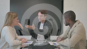 Young Man in Argument with Colleagues