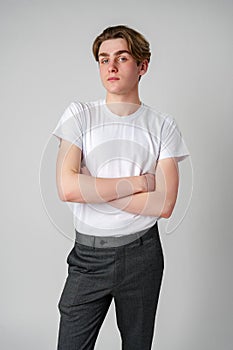 Young Man With Arms Crossed Standing Against a Plain Background in a Studio