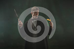 Young man in art action isolated on dark green background. Retro style, comparison of eras concept.