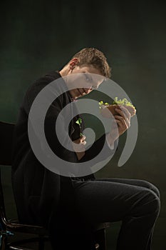 Young man in art action isolated on dark green background. Retro style, comparison of eras concept.