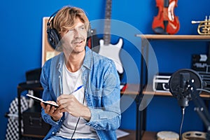 Young man artist composing song at music studio