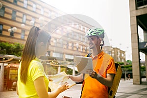 Young man as a courier delivering package using gadgets