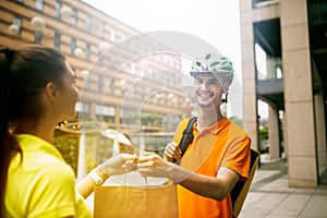 Young man as a courier delivering package using gadgets