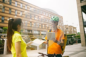 Young man as a courier delivering package using gadgets