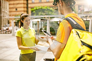 Young man as a courier delivering package using gadgets