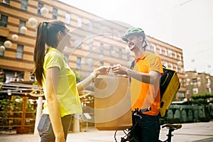 Young man as a courier delivering package using gadgets