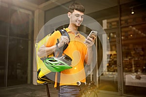 Young man as a courier delivering package using gadgets