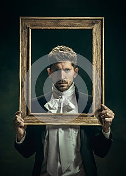 Young man as Dorian Gray on dark background. Retro style, comparison of eras concept.