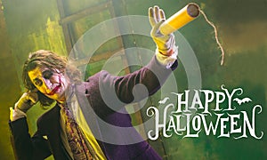 Young man as a Joker on green background, halloween time, flyer with copyspace