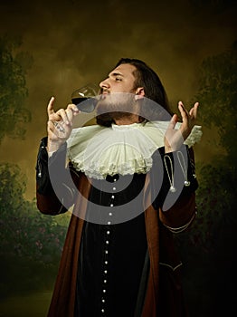 Young man as a medieval knight on dark background