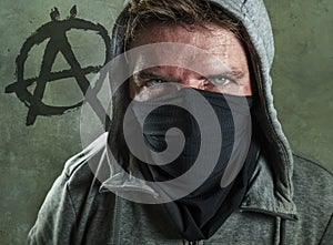 Young man as violent and ultra anarchist rioter . furious anti-system protester in face mask hostile at fighting riot in radical