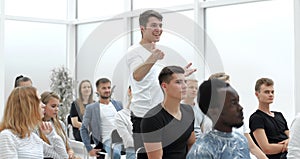 Young man asks a question at a business seminar