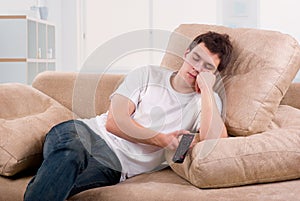 Young man asleep in front of TV photo