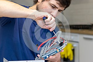 Young man assembles electronic computer components with his own hands. Hobby, technician, do-it-yourself assembly and invention