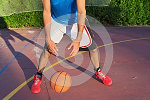 Young man athlete on basketball court dribbling