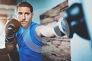 Young man athlete boxing workout in fitness gym on blurred background.Athletic man training hard.Kick boxing concept