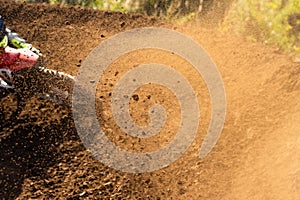 A young man, a man, an athlete, driving a motocross motorcycle in the blur, on a dirt track. Movement, blur, slow-motion
