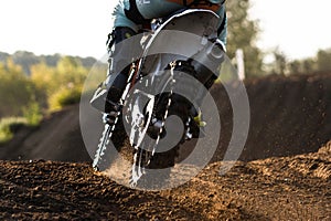 A young man, a man, an athlete, driving a motocross motorcycle in the blur, on a dirt track. Movement, blur, slow-motion