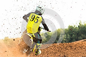 A young man, a man, an athlete, driving a motocross motorcycle on a dirt track. Movement, slow motion. Nature, field. A