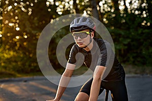 young man with athletic body shape in protective helmet and glasses riding bicycle