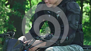 Young man on ATV corrects his hair