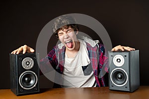 Young man audiophile listen to loud music from speakers f