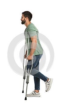 Young man with axillary crutches on white background photo