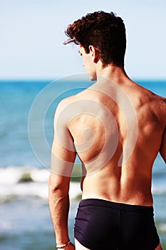 Young man from the back looking at the sea