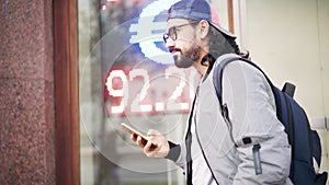 Young man on the background of a led scoreboard with the exchange rate