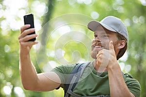 young man with backpack using smart phone on beautiful nature