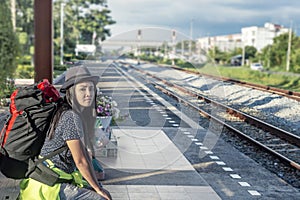 Young man with backpack waiting for next the train station.