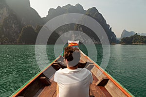 Backpacker traveling by longtail boat, in Cheow Lan Lake, Khao Sok, Thailand