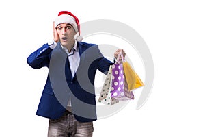 The young man with bags after christmas shopping on white background