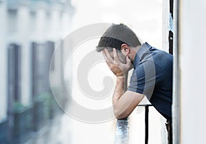 Young man at balcony in depression suffering emotional crisis and grief