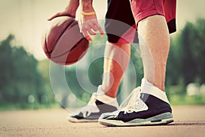 Young man on basketball court dribbling with ball