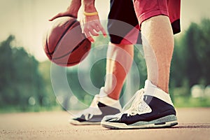 Young man on basketball court dribbling with ball photo