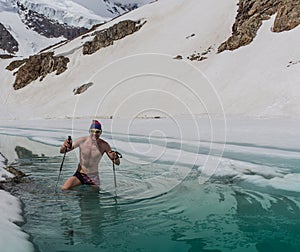 Young man bathing in the ice hole